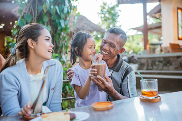 asian grandfather bonding with cute grandchild by having lunch together