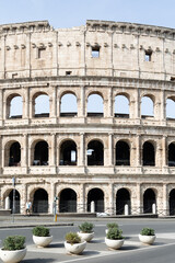 Naklejka premium Rome, Italy - April 09, 2024: Ruins of the Coliseum with tourists strolling among the archaeological remains in Rome, Italy