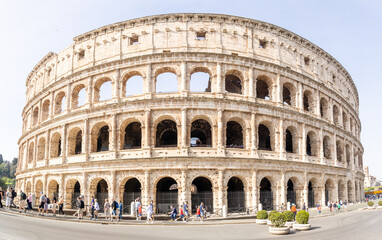 Naklejka premium Rome, Italy - April 09, 2024: Ruins of the Coliseum with tourists strolling among the archaeological remains in Rome, Italy