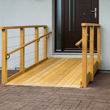 Modern home entrance featuring a wooden wheelchair ramp for easy access, surrounded by greenery. Designed for convenience and inclusivity, blending functionality with minimalist aesthetics.