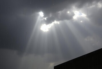 Rainy Day Rays breaking through dark clouds during a downpour cr