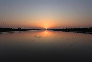 River Sunset A peaceful sunset reflected in the calm waters of a
