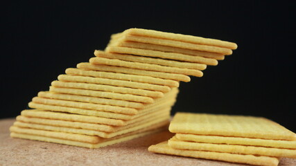 Stack of salted biscuits crackers on black background
