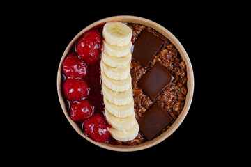 Healthy breakfast with whole oats, oat milk, chia seeds, cocoa, strawberries, honey, banana, and dark chocolate