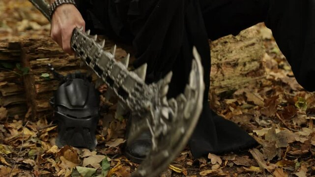 Spiked weapon, Forest hammer, Forest staff. Cloce up spiked, metal weapon lying on fallen leaves in forest, with boots visible in background.