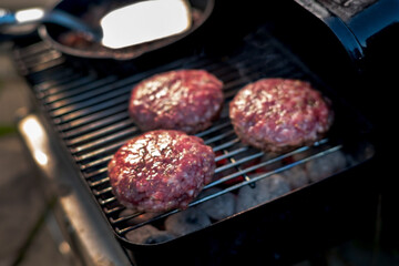 grilling hamburgers on barbecue grill,