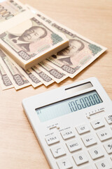 テーブルに置かれた106万円と電卓