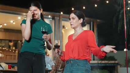 Family gather celebrate holiday. Mother and grandmother drink wine and talking at dinner party for...
