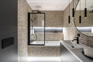 Modern bathroom interior design featuring a sleek shower and bathtub at night