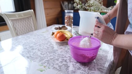 Happy attractive young woman, housewife, baker, cooking, preparing breakfast for family, preparing homemade pizza at home, baking pastry. Making homemade dough on the kitchen table