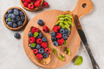 Sandwiches with chocolate paste, raspberries and blueberries
