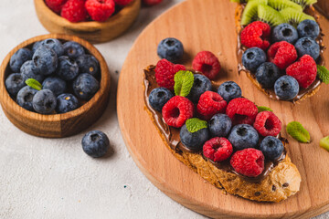 Sandwiches with chocolate paste, raspberries and blueberries