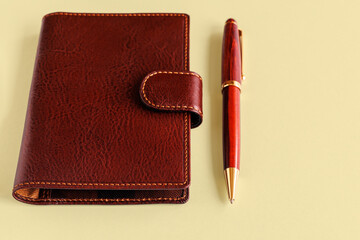Leather wallet and fountain pen on a light background. Business concept.