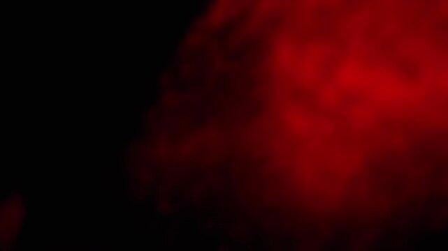 Abstract red smoke billows and swirls against a dark backdrop, creating a dramatic and mysterious atmosphere. Perfect for adding a touch of intensity or suspense to any project.