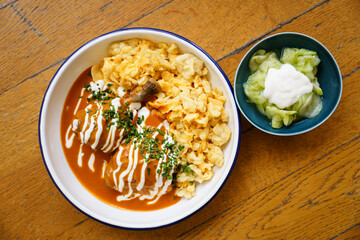 Top down view of traditional Hungarian chicken paprikash with spaetzle and cucumber salad