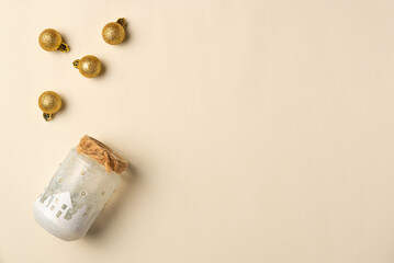 Christmas handmade jar with balls on beige background. Flat lay, top view. Copy space