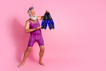 Photo of positive optimistic senior man wear swimwear summer resort flippers diving goggles tube isolated on pink color background © deagreez