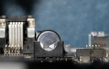 3 Volts lithium cell on the main board Battery-backed electronic devices. Focused on the battery.