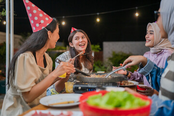 Friends are enjoying a joyful barbecue outdoors with laughter, love, and delicious food