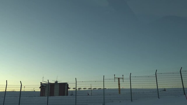 Stockholm, Sweden A plane lands at Arlanda Airport over a snowy landscape at sunset. 
