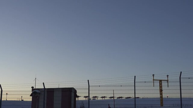 Stockholm, Sweden A plane lands at Arlanda Airport over a snowy landscape at sunset. 