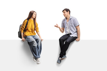 Teenage female student sitting on a panel and listening to a young man