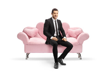 Businessman sitting on a pink sofa