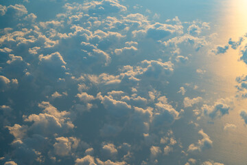 Clouds scattered across the sky reflecting sunlight over a vast ocean during sunset