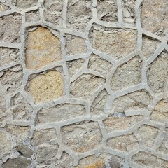 Close-up of a textured stone wall with irregular shapes.