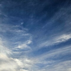 Expansive blue sky dotted with wispy white clouds.