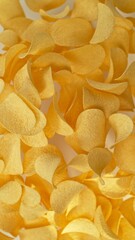 Freeze motion of flying fried potatoes chips on gradient yellow background