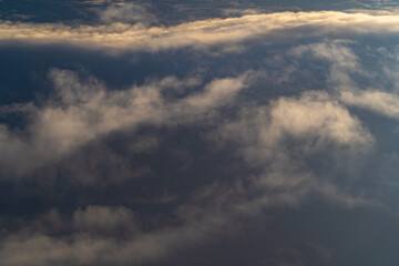 Vast expanse of clouds revealing a dramatic contrast between sunlight and shadows during the late afternoon sky
