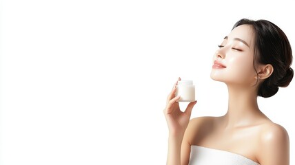 A serene woman enjoying skincare, radiating beauty and confidence in a minimalist setting.