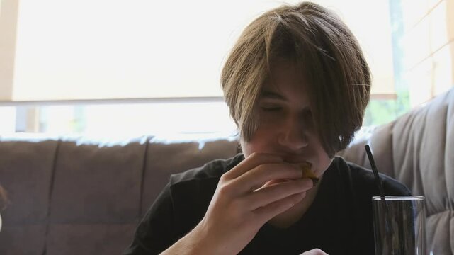 Young man savoring a cheesy pizza slice in slow motion, enjoying the delicious pull of cheese as he takes a bite