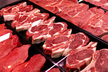 Raw fresh meat ribeye for steak perfectly arranged in trays. Red rib eye for sale in meat department in a shop. Food industry cocept.