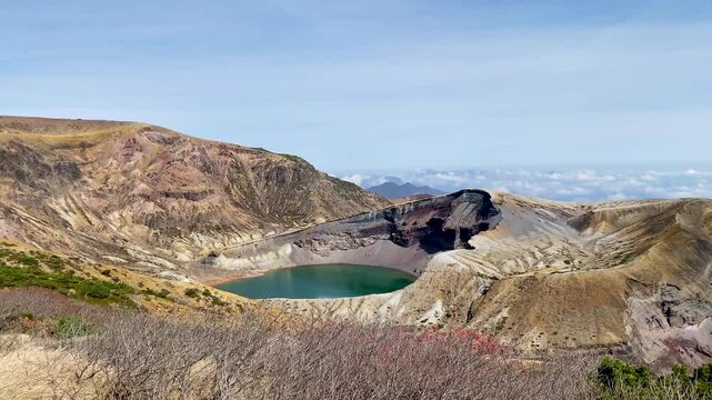 Okama Crater Lake on the sunny day. While local people call it affectionately Okama, the visitors tend to call it "Five Color Pond", because its color changes.