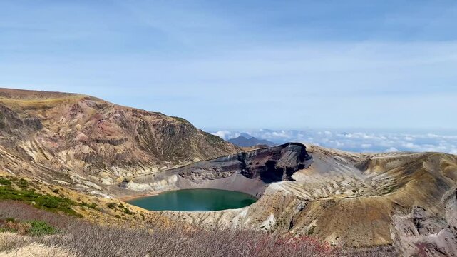 Okama Crater Lake on the sunny day. While local people call it affectionately Okama, the visitors tend to call it "Five Color Pond", because its color changes.