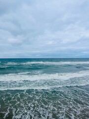 Cloudy seascape, seashore waves, natural sea horizon, cloudy sky
