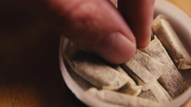 Snus nicotine tobacco close up, pack of tobacco for gum. unhealthy addiction.