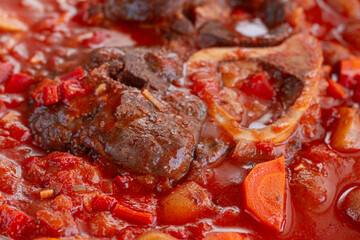 ossobuco stew with vegetables, knuckle on the bone with new potatoes, in tomato sauce,homemade, top view, no people,