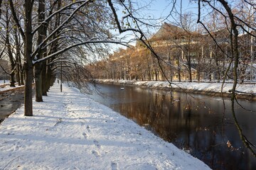 First snow, winter, a canal in a park in Warsaw, a stadium in the distance