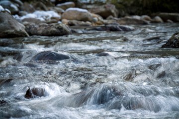 water from a mountain creek in long exposure photography at a cold autumn day