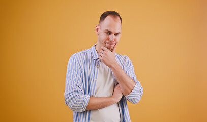 Young man in pose of doubt, thinking hard on idea or creative insight