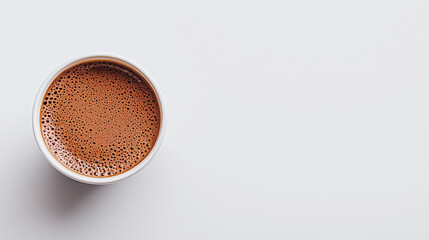 Frothy hot chocolate in white cup on minimalist background