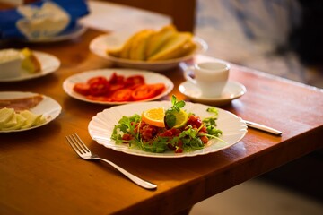 Fresh tuna tartare, topped with mint and citrus, served on a wooden table, part of a larger breakfast display.
