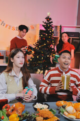 Friends opening Christmas gifts in living room