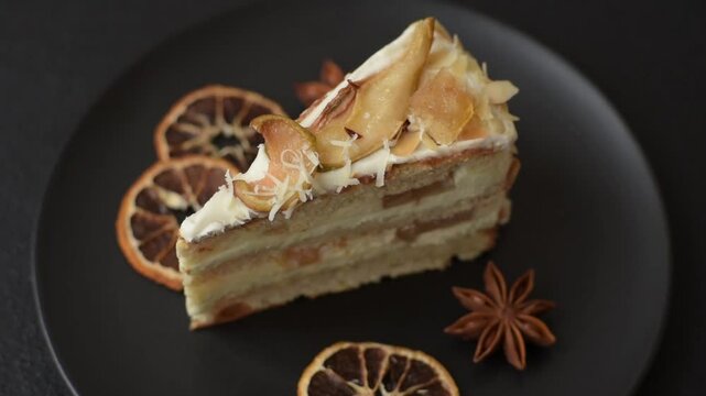Layered sweet cake with cream, pear and dorblu cheese on a dark concrete background