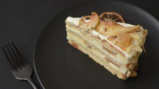 Layered sweet cake with cream, pear and dorblu cheese on a dark concrete background