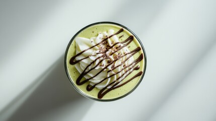 Fototapeta premium 柔らかな光の中でホイップクリームとチョコレートをトッピングした輝く抹茶ドリンク