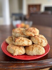 Homemade mouthwatering biscuits made from scratch displayed on a red plate.